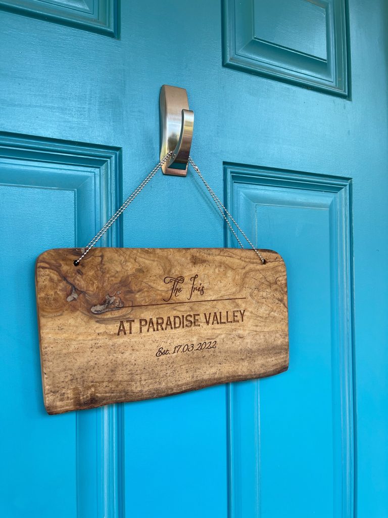 Blue entrance door with door hanger that states when the business was established.
